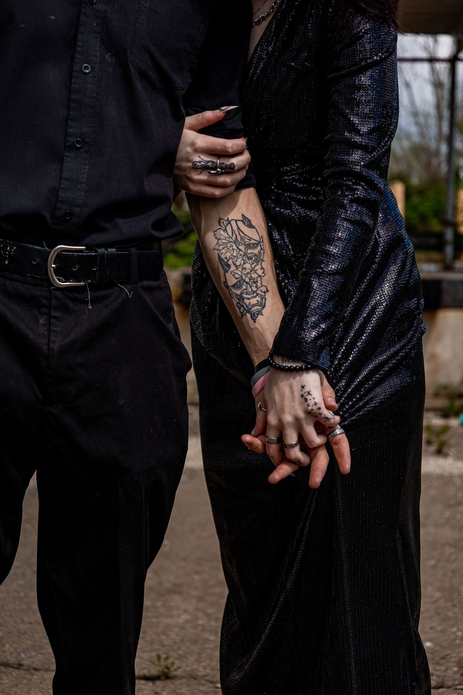 Close-up of couple holding hands showing detailed tattoo artwork.