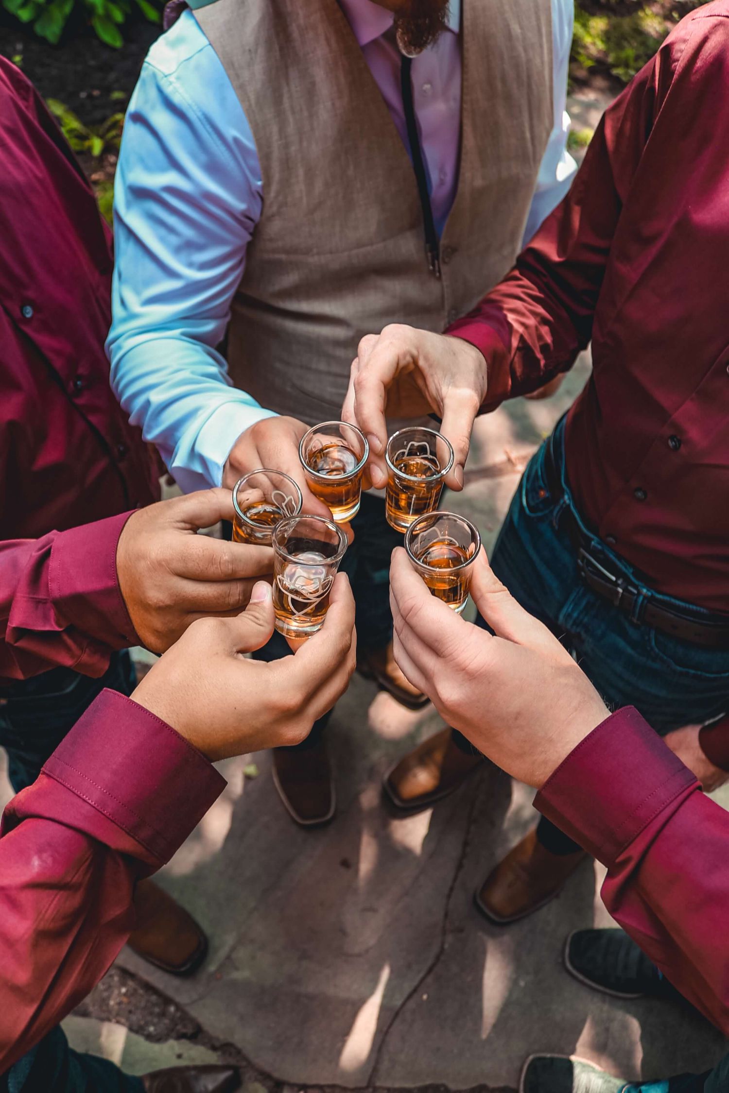 People in formal attire toasting with small glasses of liquor.