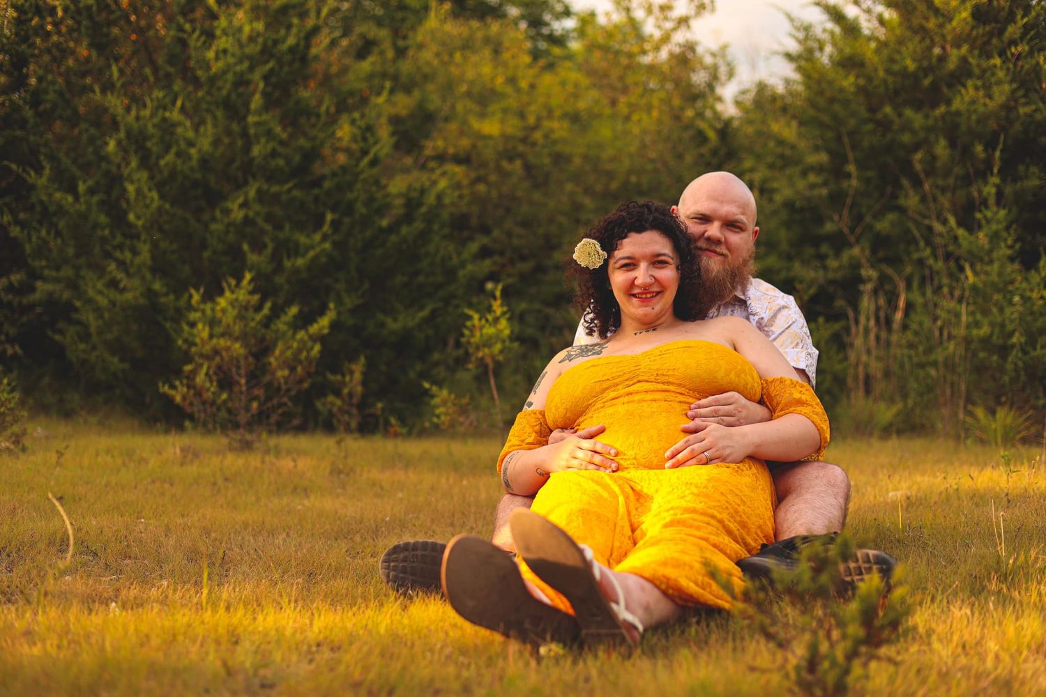 Family photoshoot in a golden field during sunset wearing bright yellow and white outfits.