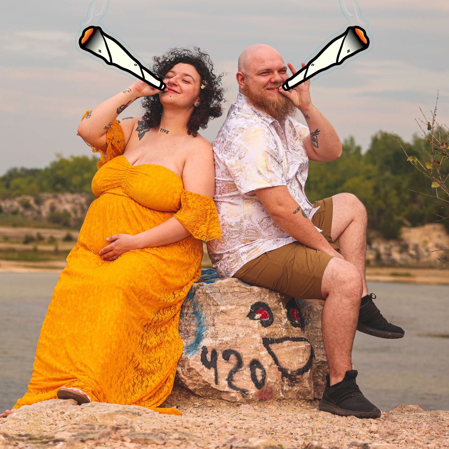 Couple sitting on rocks by the water during sunset in casual attire.
