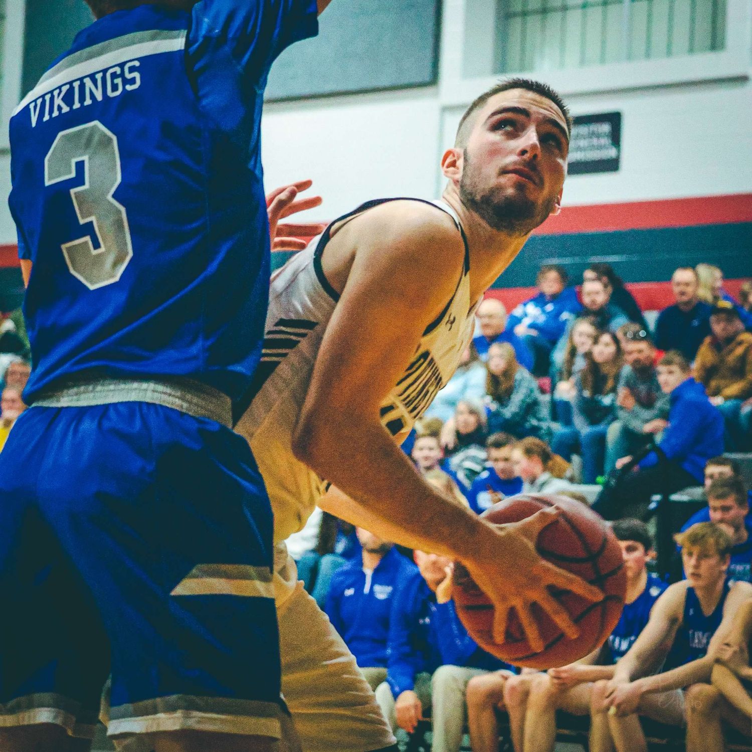 Basketball player attempts to score while defended during competitive game.