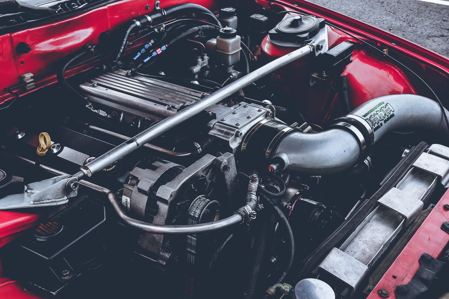 Close-up shots of a red car's engine bay and mechanical components.