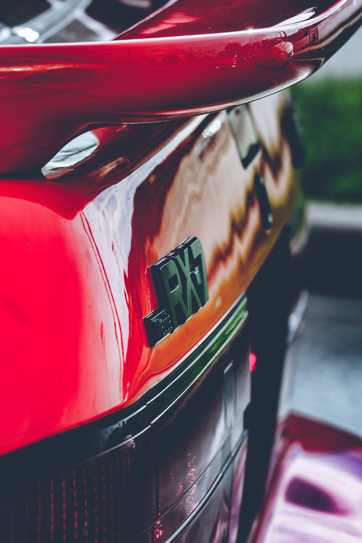 Close-up detail shot of a glossy red car's bodywork and curves.