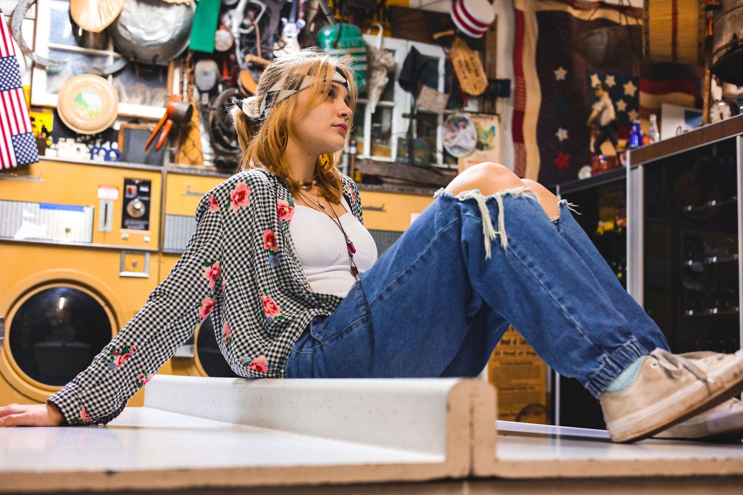 Woman in vintage striped jacket lounges casually in retro-themed setting.
