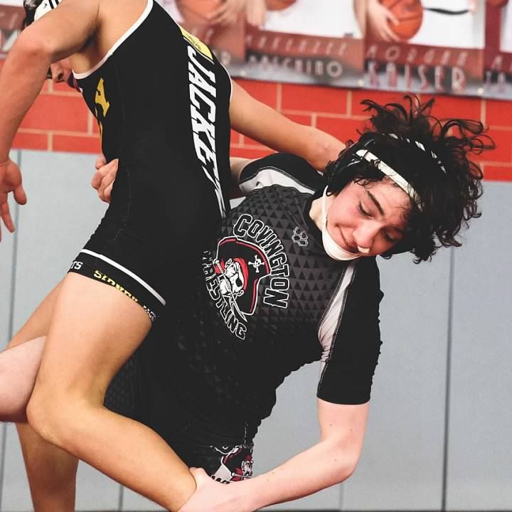 Athletes in black uniforms performing dynamic stretching exercises.