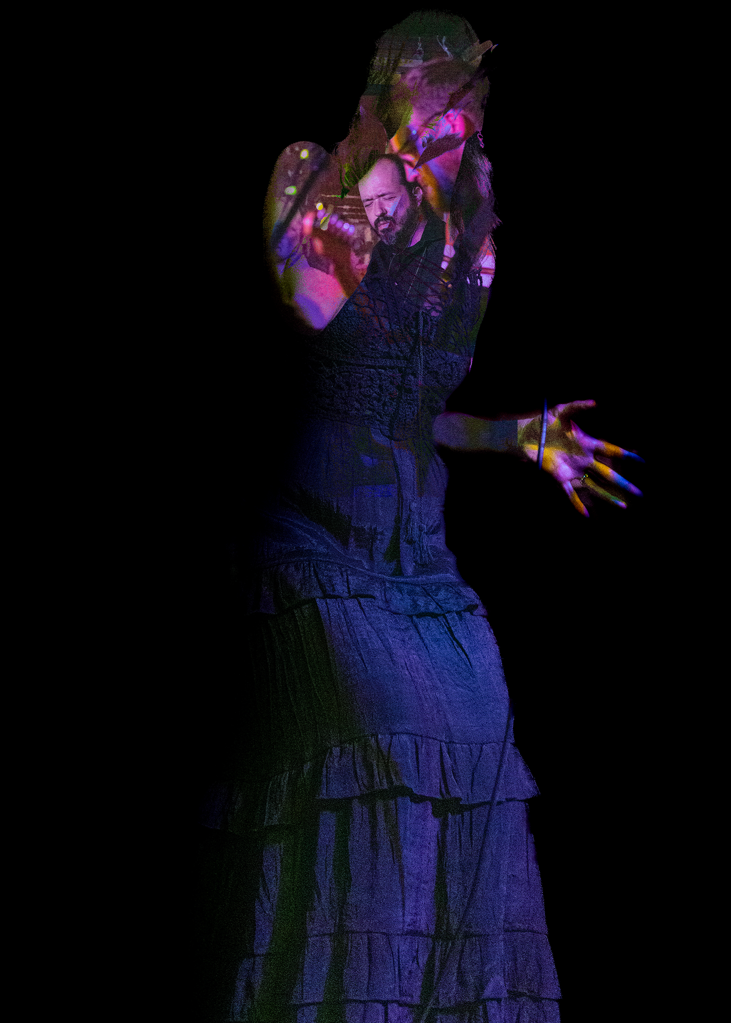 A woman in a dark blue ruffled gown poses dramatically under colorful purple and pink stage lighting.