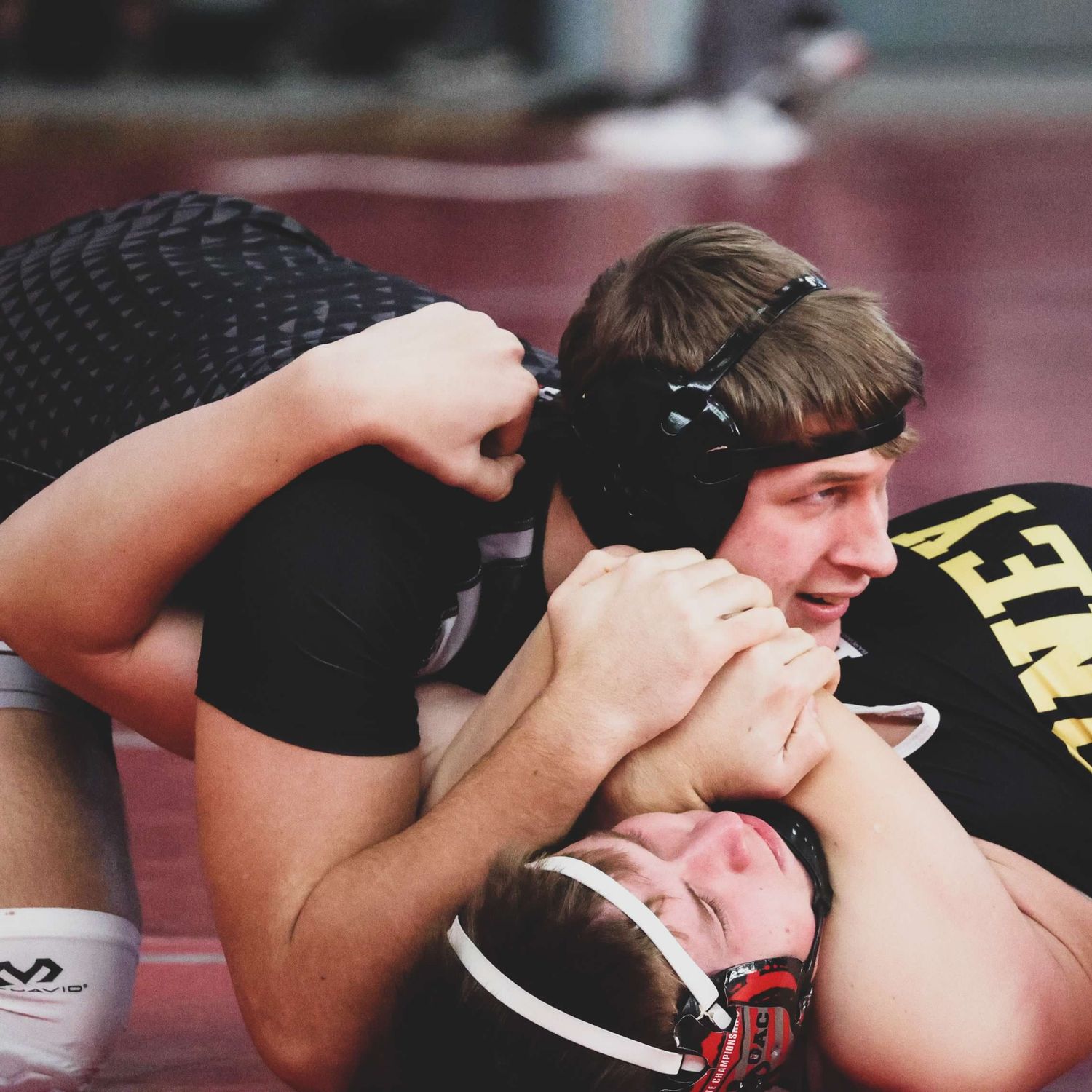 Two wrestlers competing in an intense match on the mat.