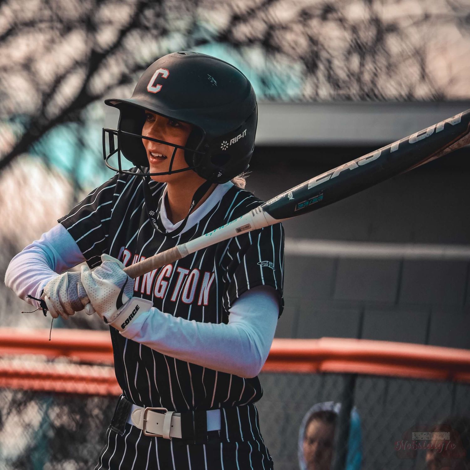 Baseball player in pinstripe uniform prepares to bat at home plate.