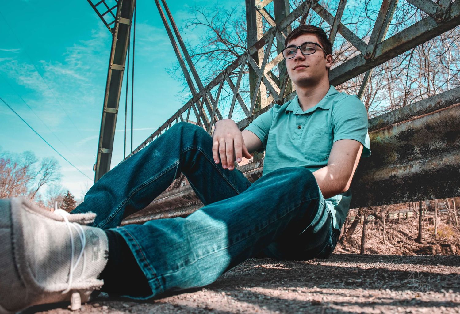 Casual outdoor photoshoot by a lake with turquoise water reflections.