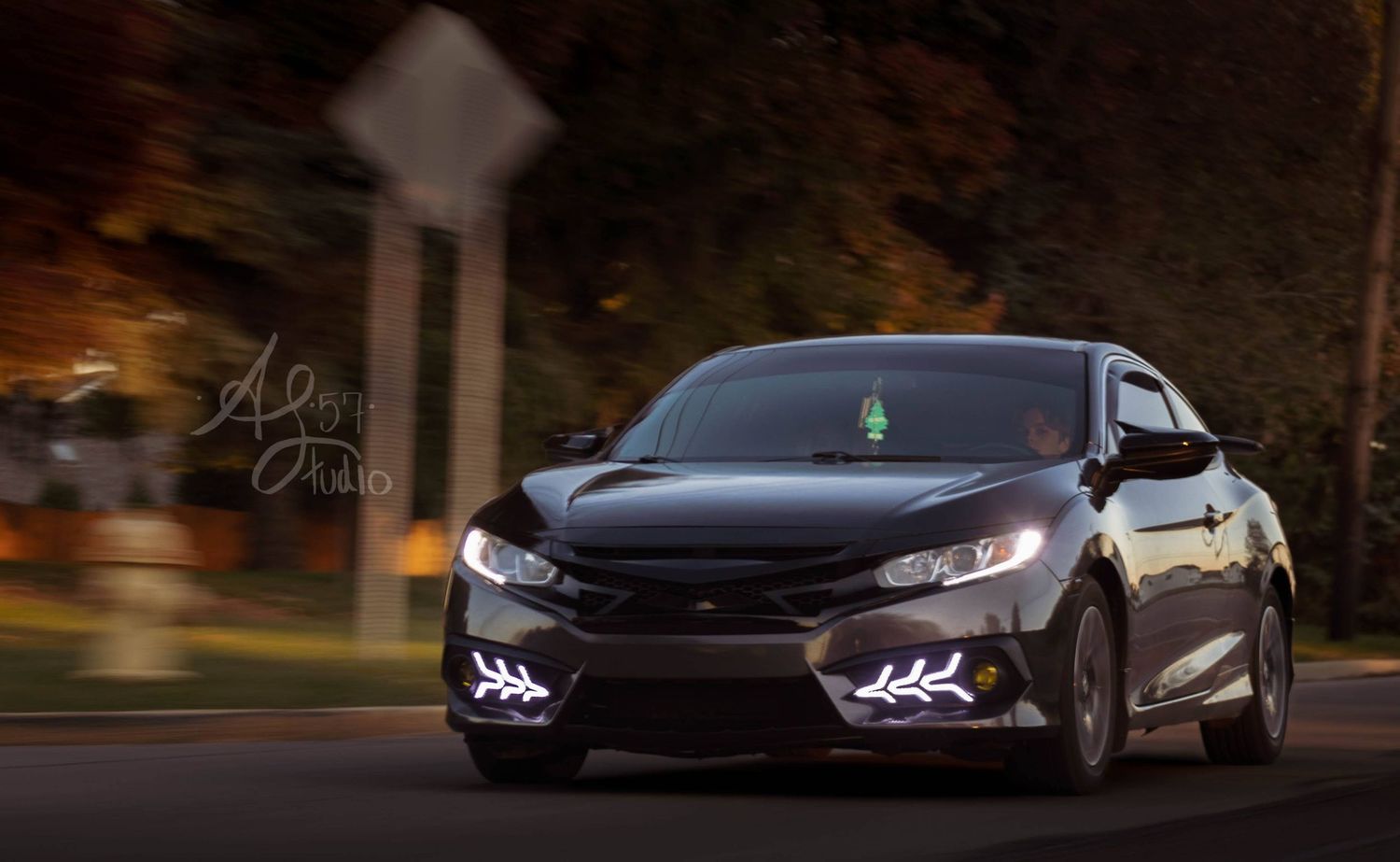 Dark sports cars with illuminated LED headlights photographed at night.