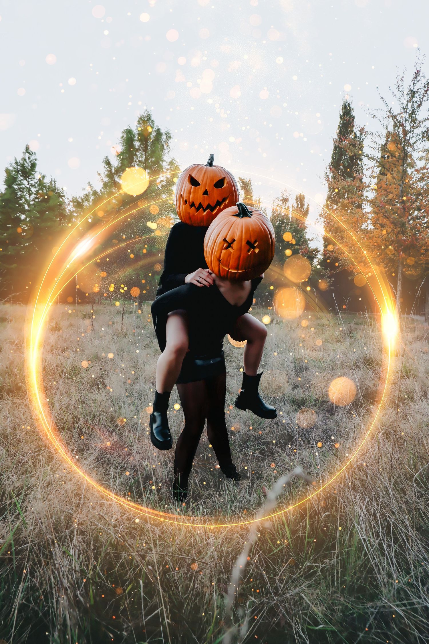 Couple wearing jack-o-lantern pumpkin heads embrace in a glowing magic circle in an autumn field at Halloween.