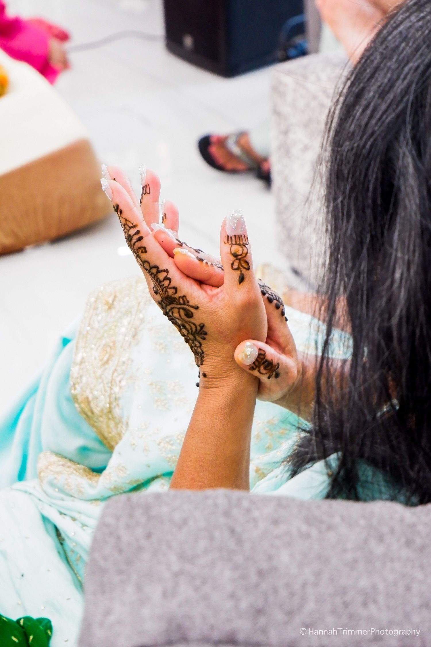 Close-up of intricate henna mehndi design on a woman's hands during an Indian wedding celebration.