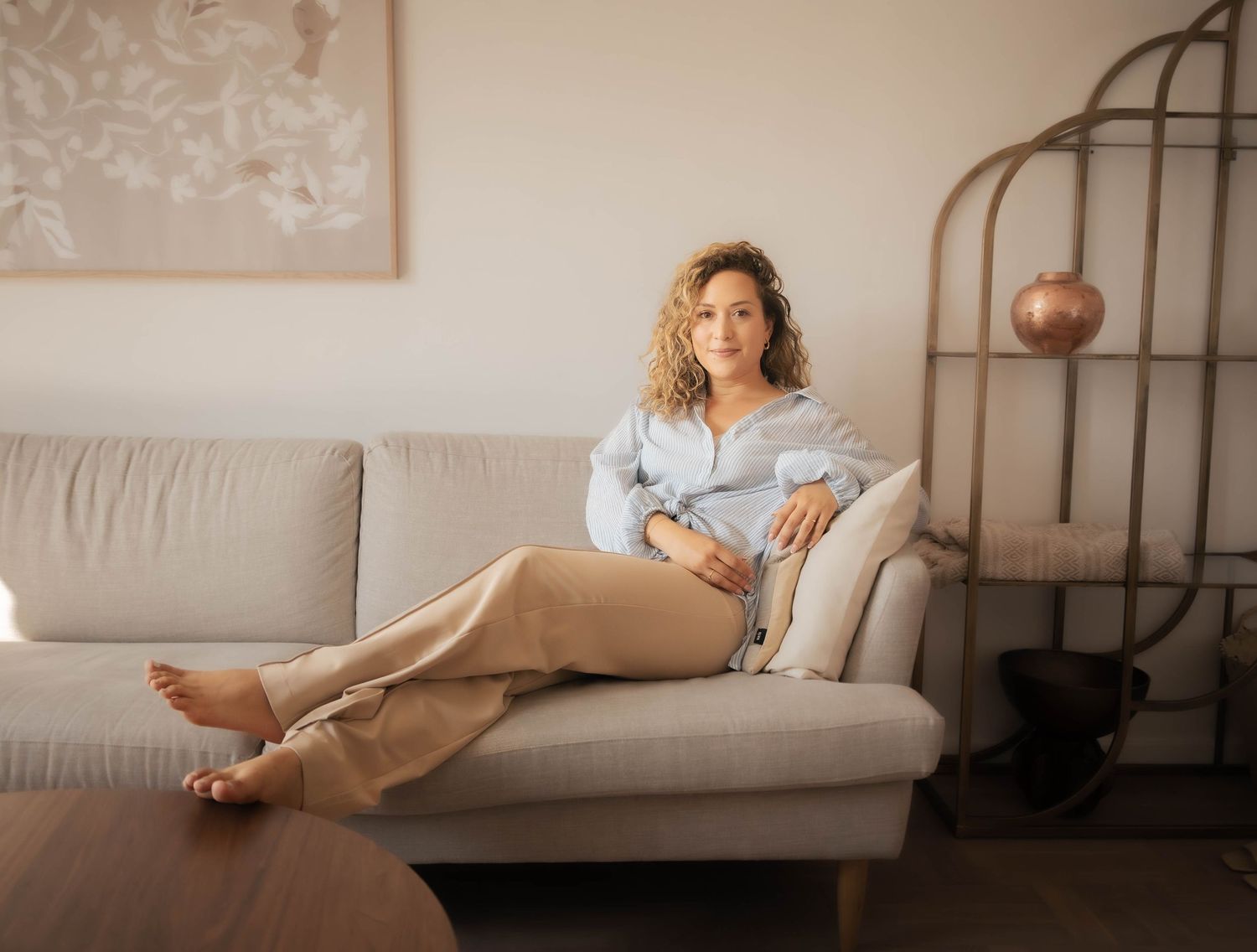 Portrait Photography of a young woman posing on her living room sofa. Captured by Photopazo, a photographer in Malmö, Sweden.
