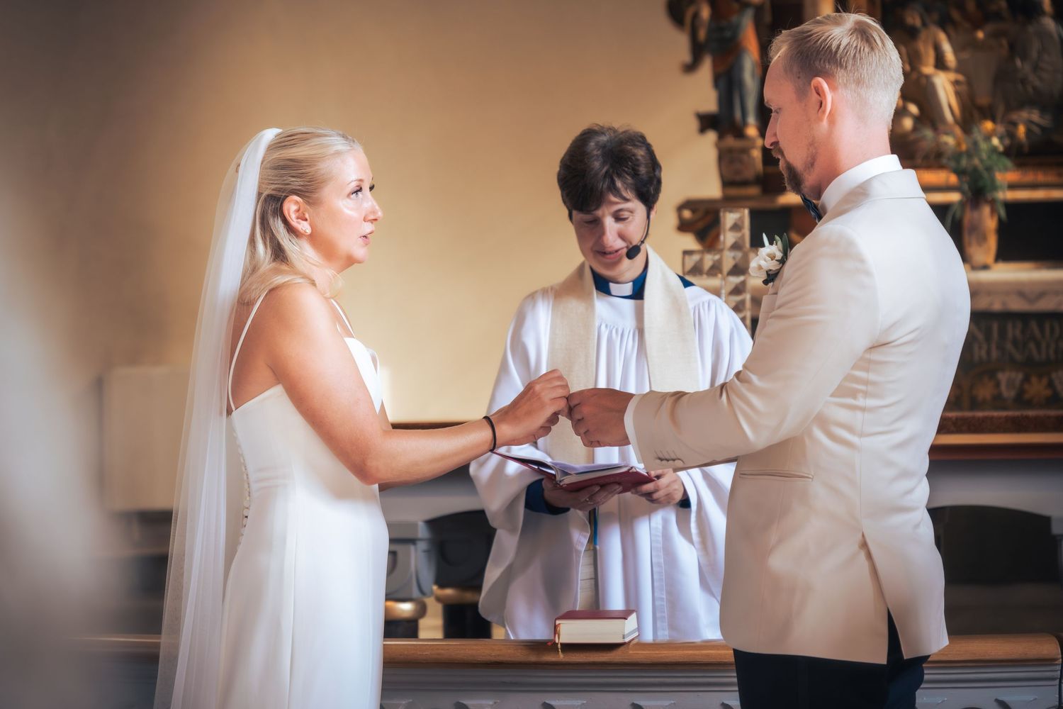 Wedding Photography of a couple exchanging rings at the altar. Captured by Photopazo, a photographer in Malmö, Sweden.