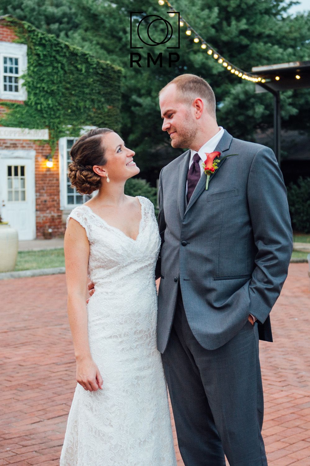 Virginia Wedding. Rachel Mares Photography. Bride and groom looking lovingly at each other in red brick courtyard with bistro lights.