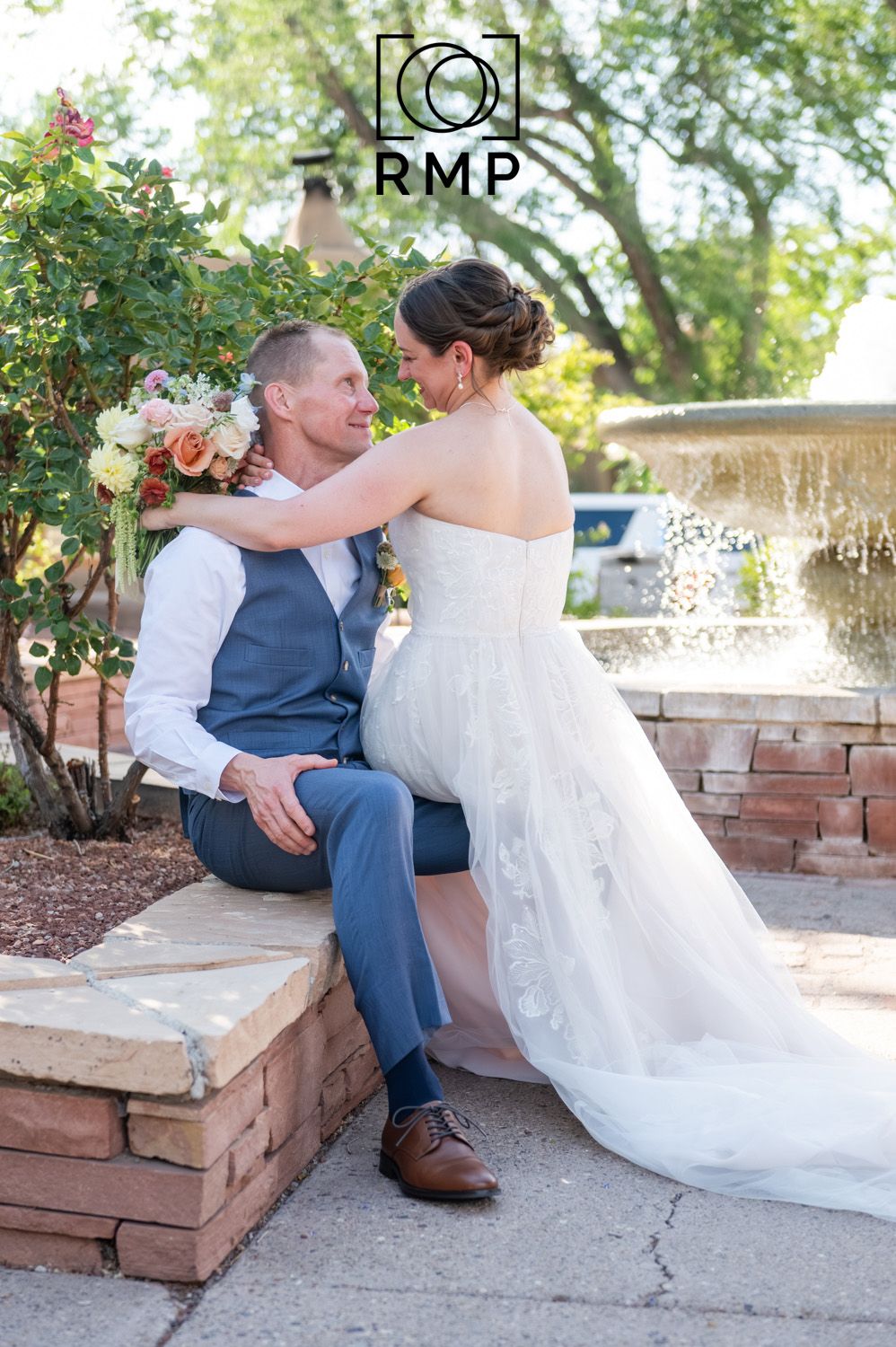 La Posada de Santa Fe, a Tribute Portfolio Resort & Spa. Rachel Mares Photography. Wedding couple by fountain gazing joyously at each other.
