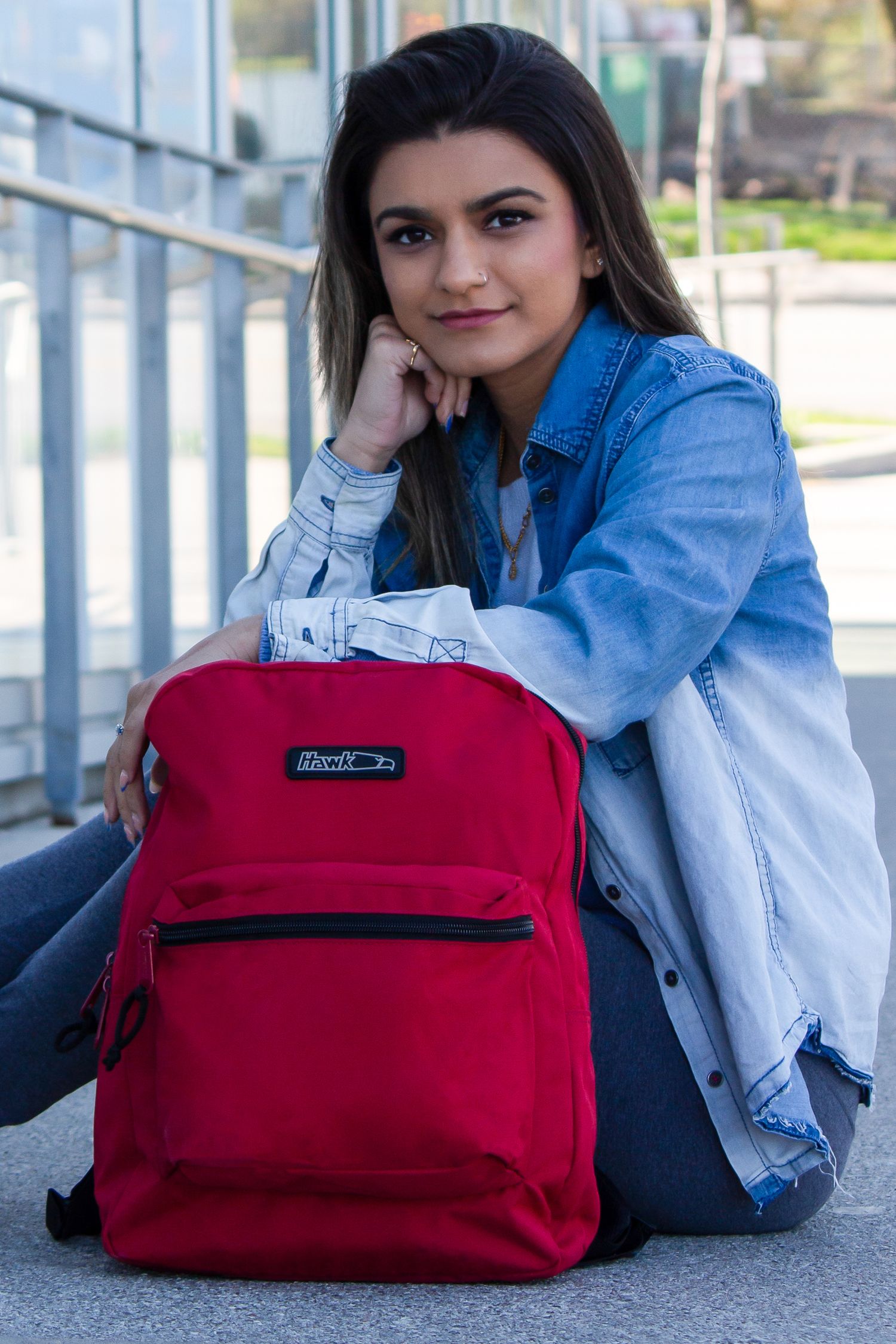 Toronto Portrait Photographer - Student with red backpack sitting casually outdoors in denim jacket.