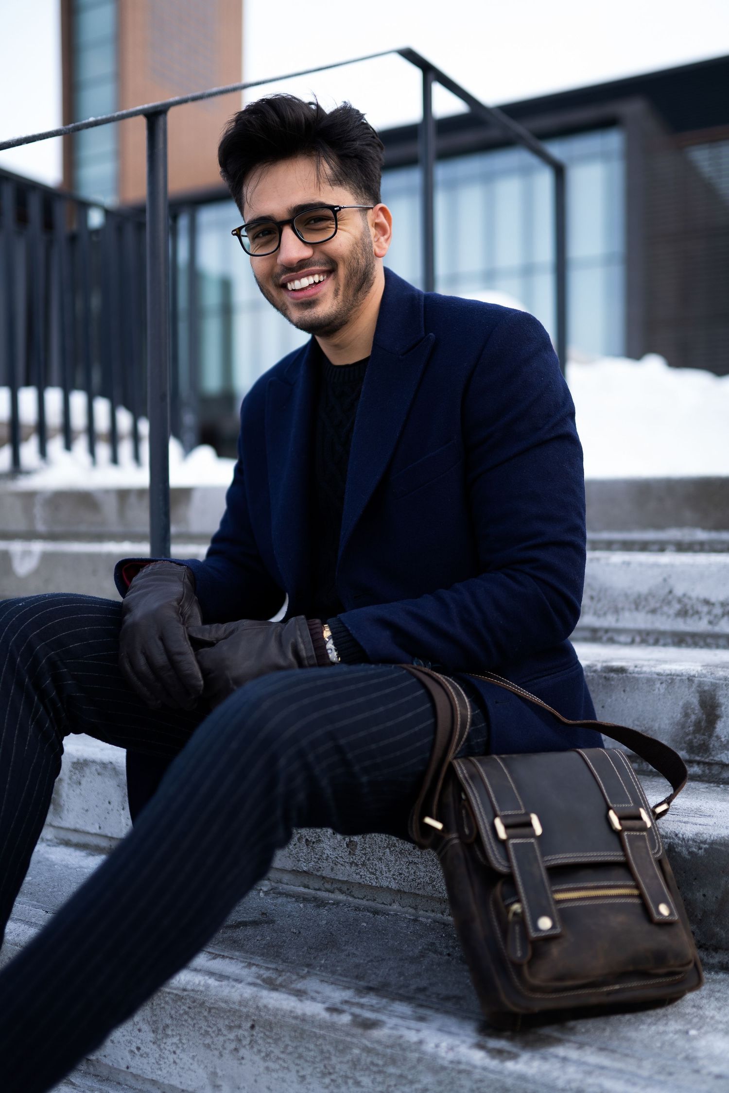 Toronto Portrait Photographer - Relaxed winter fashion portrait on concrete steps with leather messenger bag.