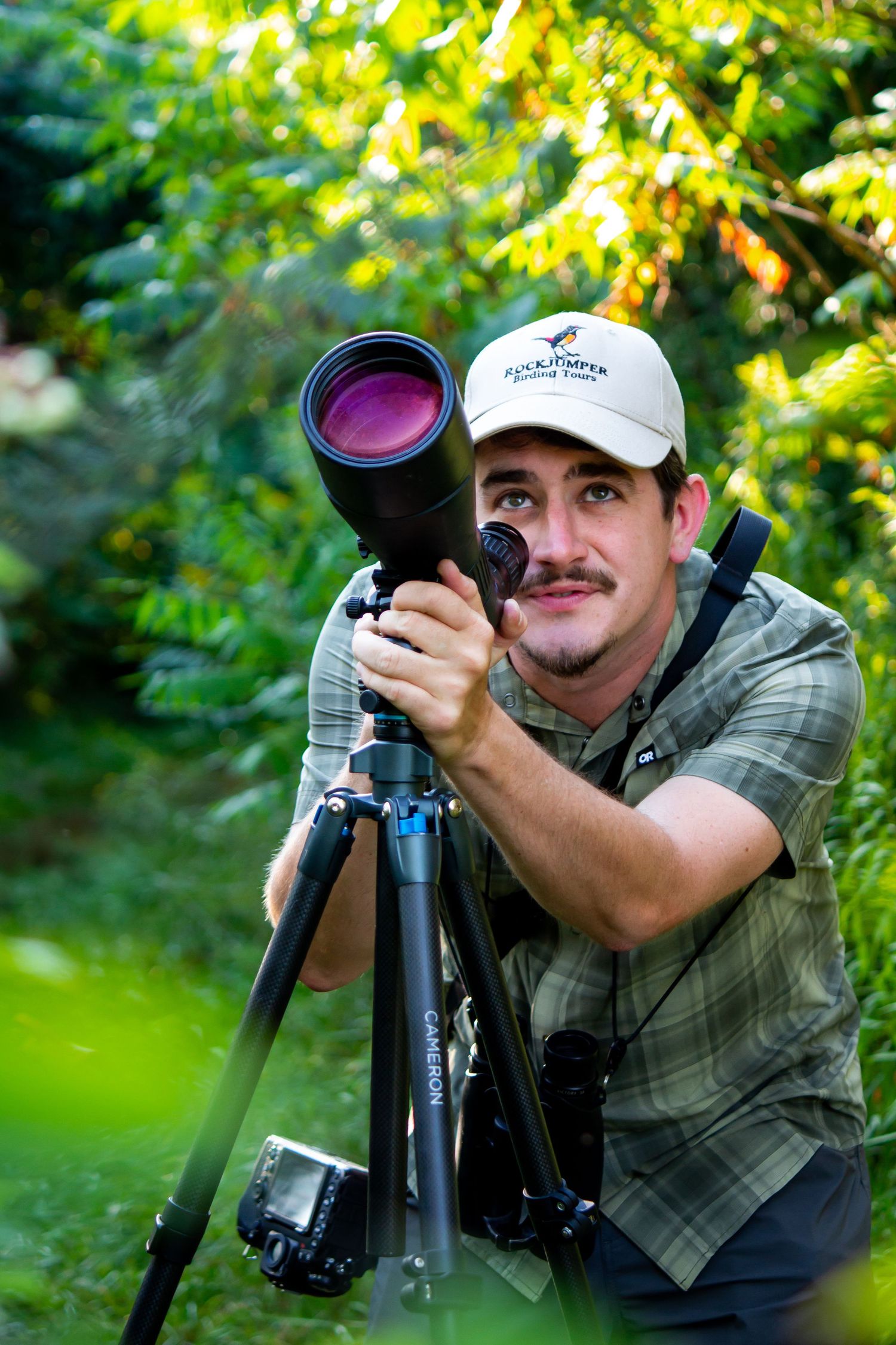 Toronto Portrait Photographer - Nature photographer with telephoto lens and tripod shooting in green foliage.