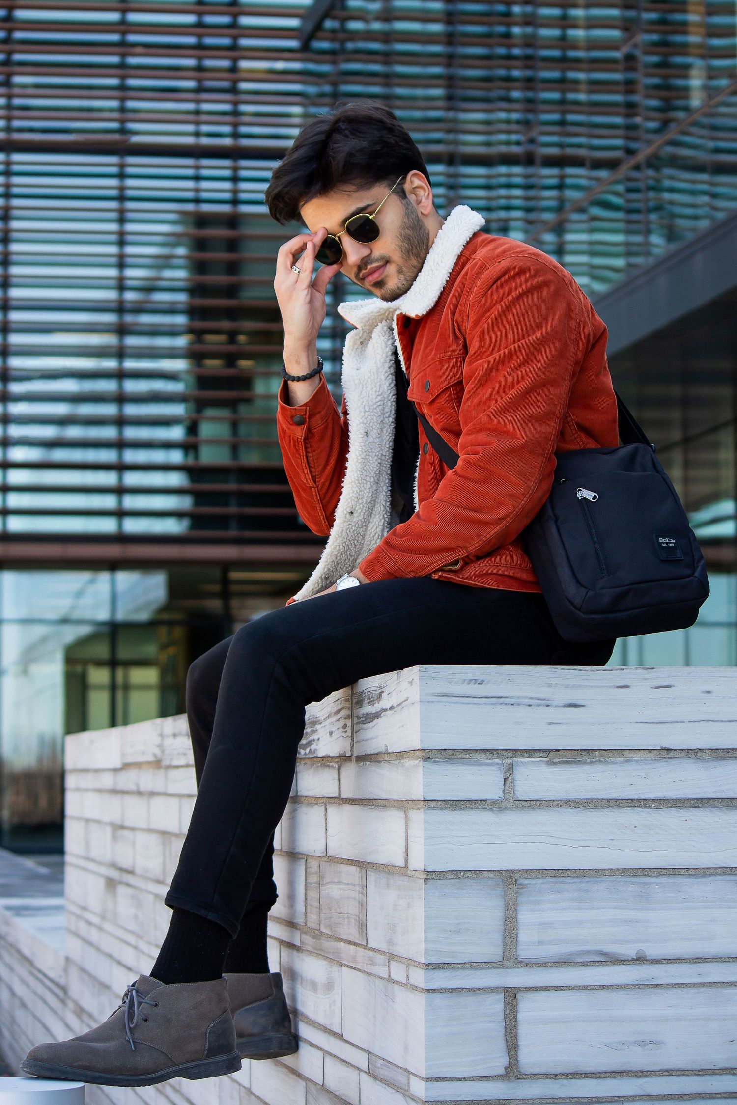 Toronto Portrait Photographer - Person in red corduroy jacket and sunglasses sitting casually on white steps.
