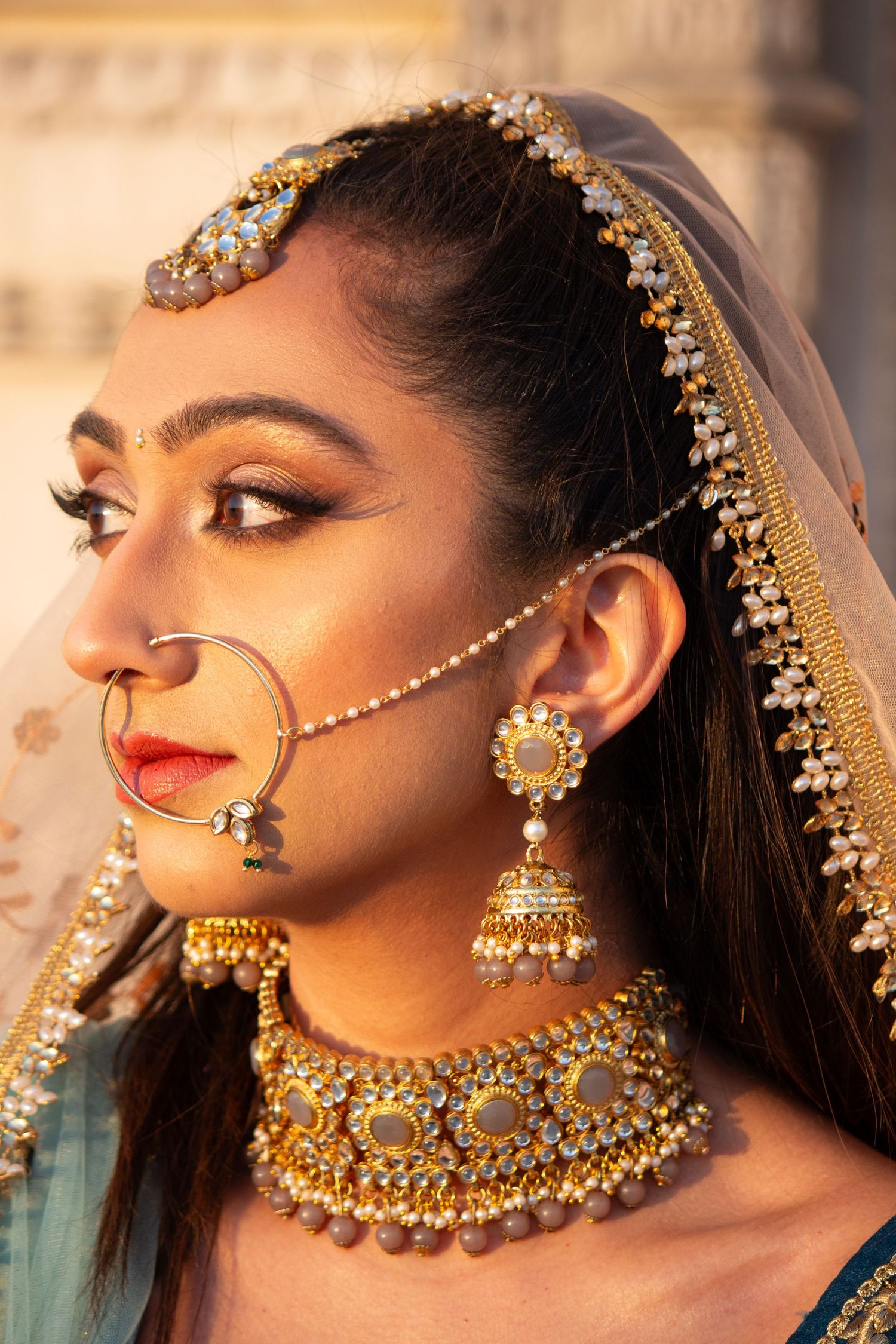 Toronto Portrait Photographer - Close-up of traditional Indian bridal jewelry and makeup with ornate gold accessories.