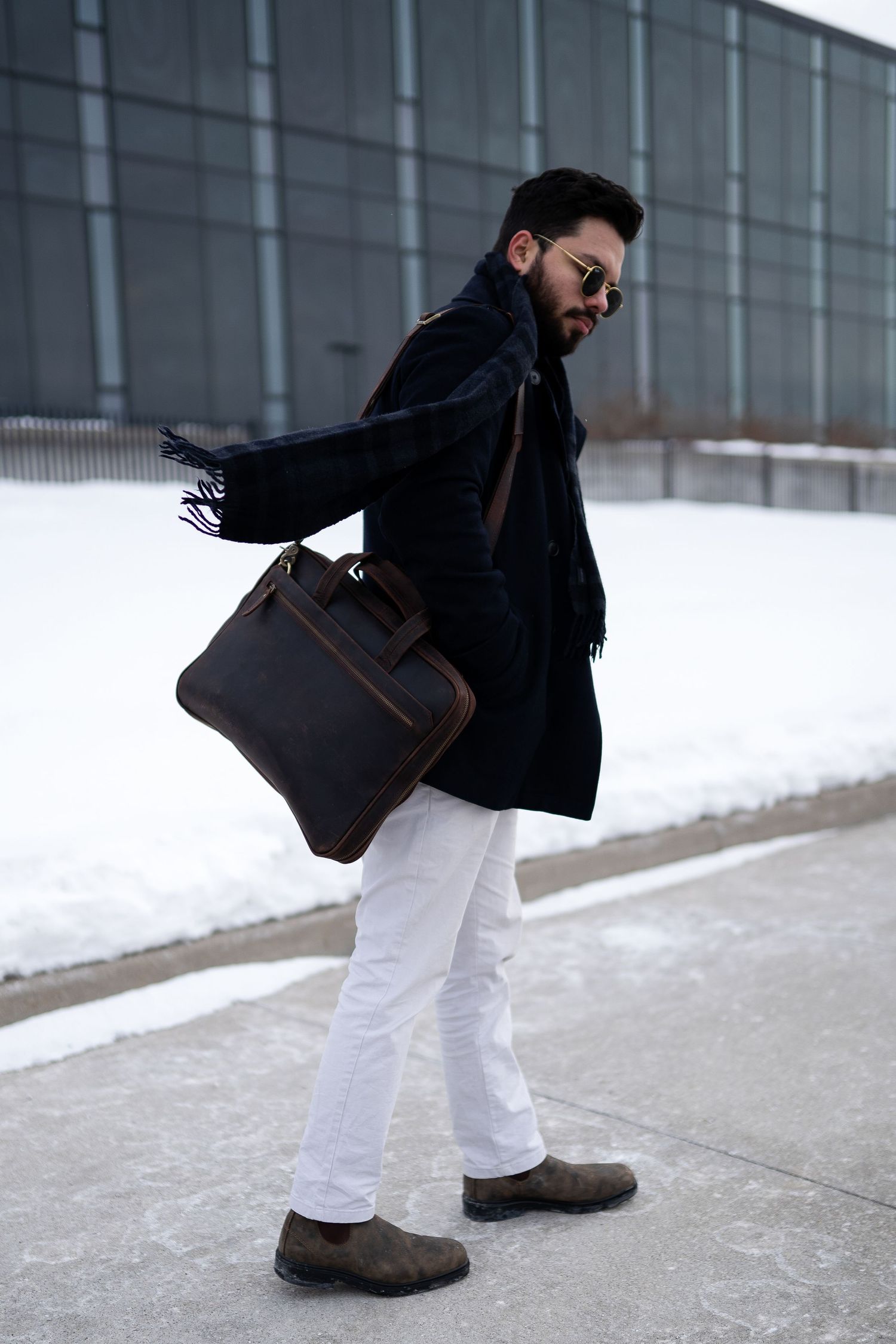 Toronto Portrait Photographer -  Winter street style featuring black coat and brown leather bag against snowy background.