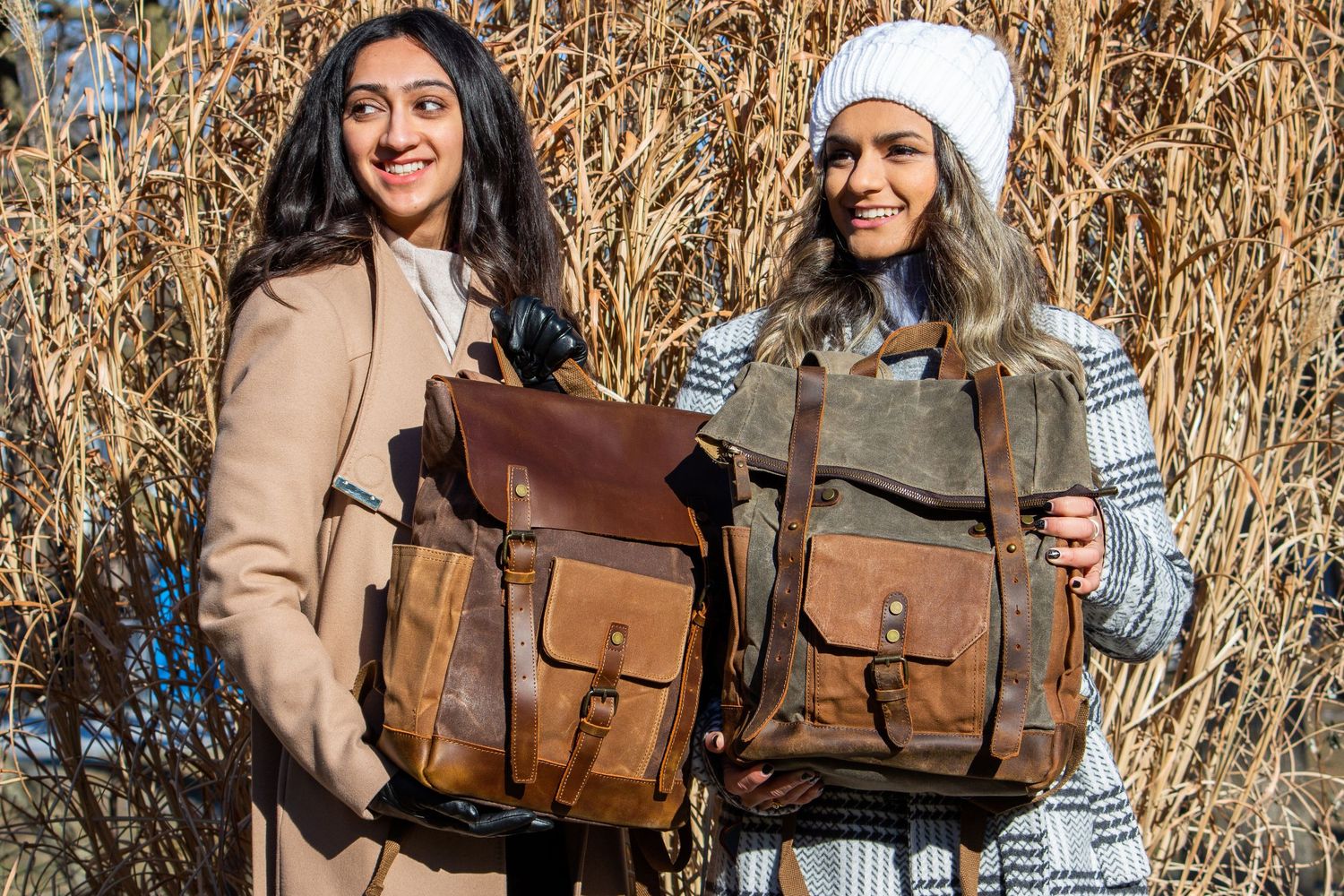 Toronto Portrait Photographer - Two people pose with vintage-style leather backpacks against dried grass background.