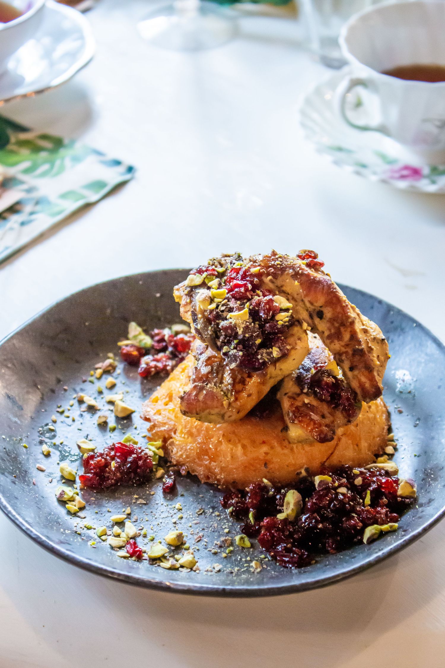 Toronto Event Photographer - Golden pastries topped with mixed berries and nuts served on dark plates.