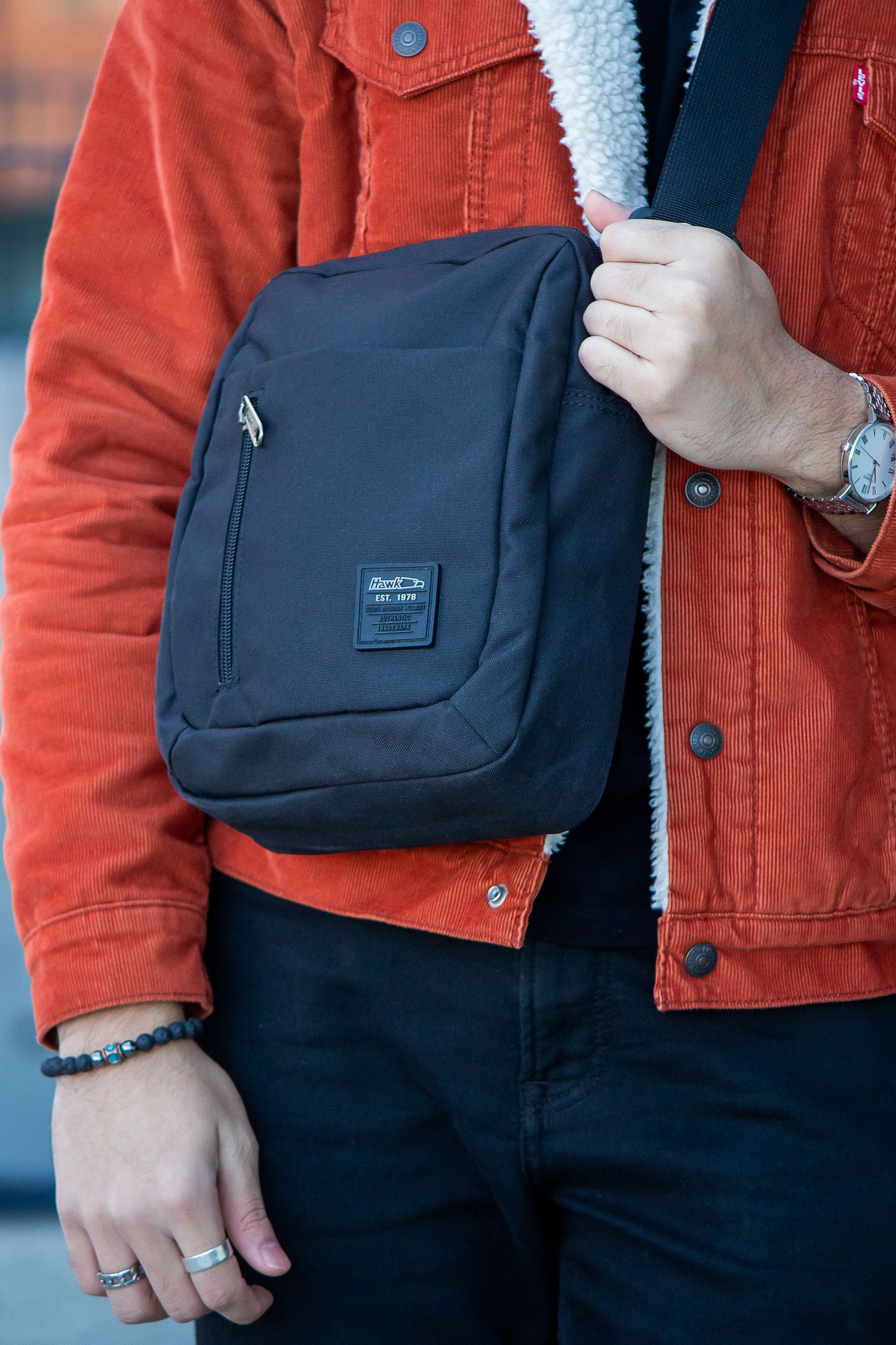 Toronto Product Photographer - Close-up view of a navy blue canvas shoulder bag paired with a rust orange jacket.