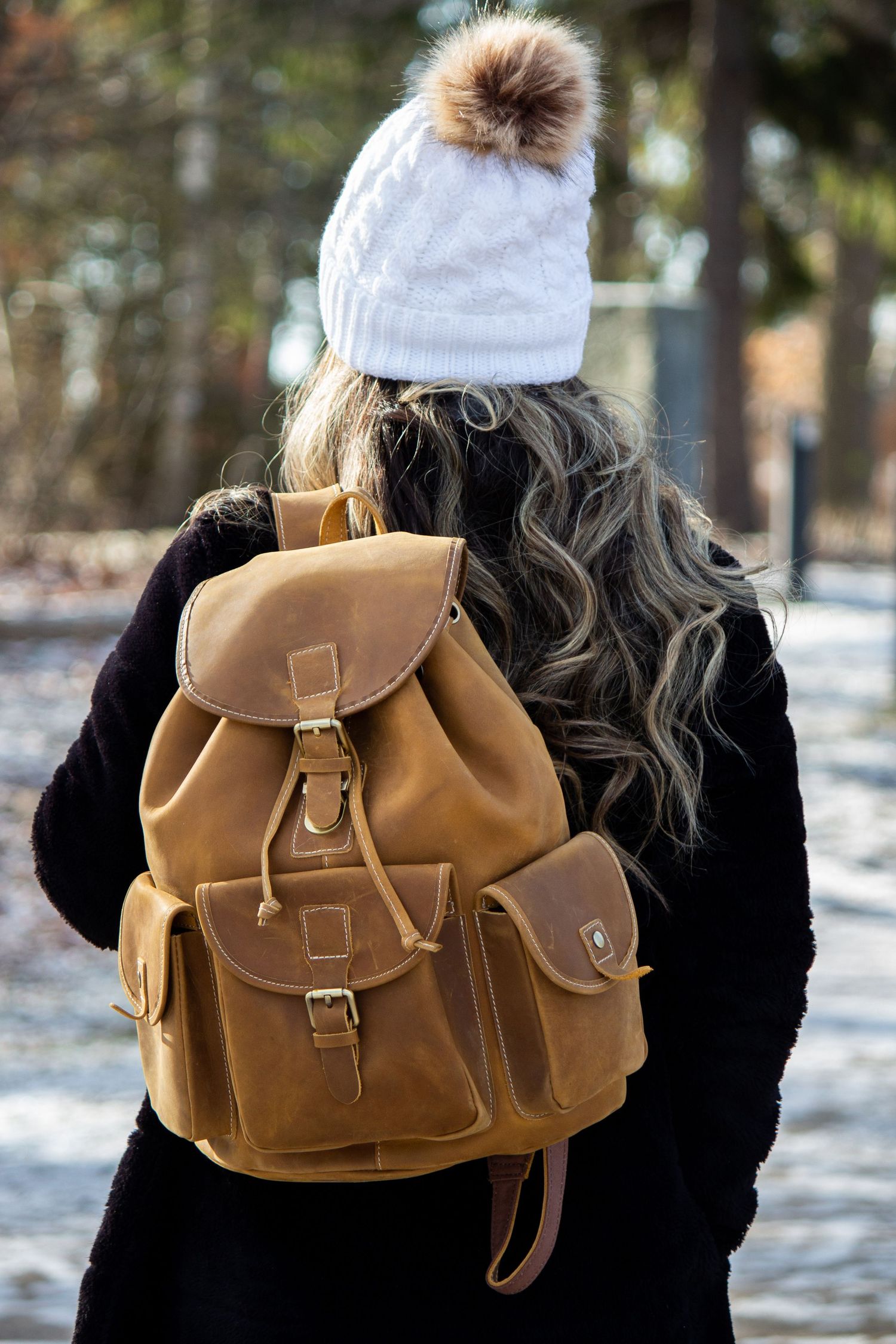 Toronto Product Photographer -Tan leather backpack shown against snowy winter background.