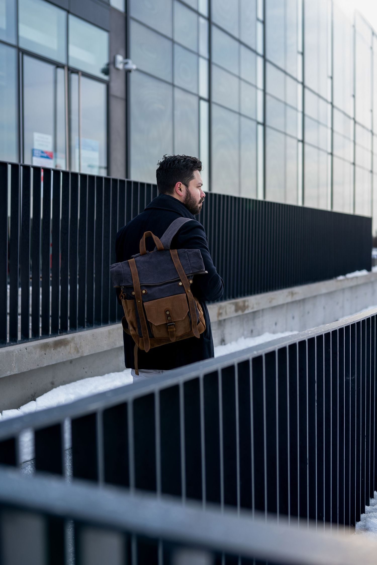 Toronto Portrait Photographer - Artistic urban photograph showing silhouette with bag against modern glass building.