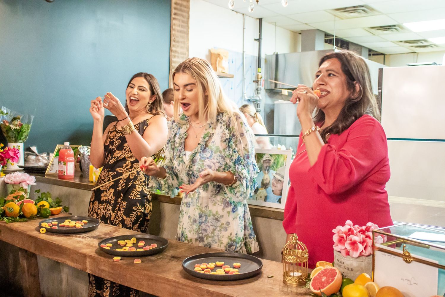 Toronto Event Photographer - Three women laughing while eating at casual dining setting.