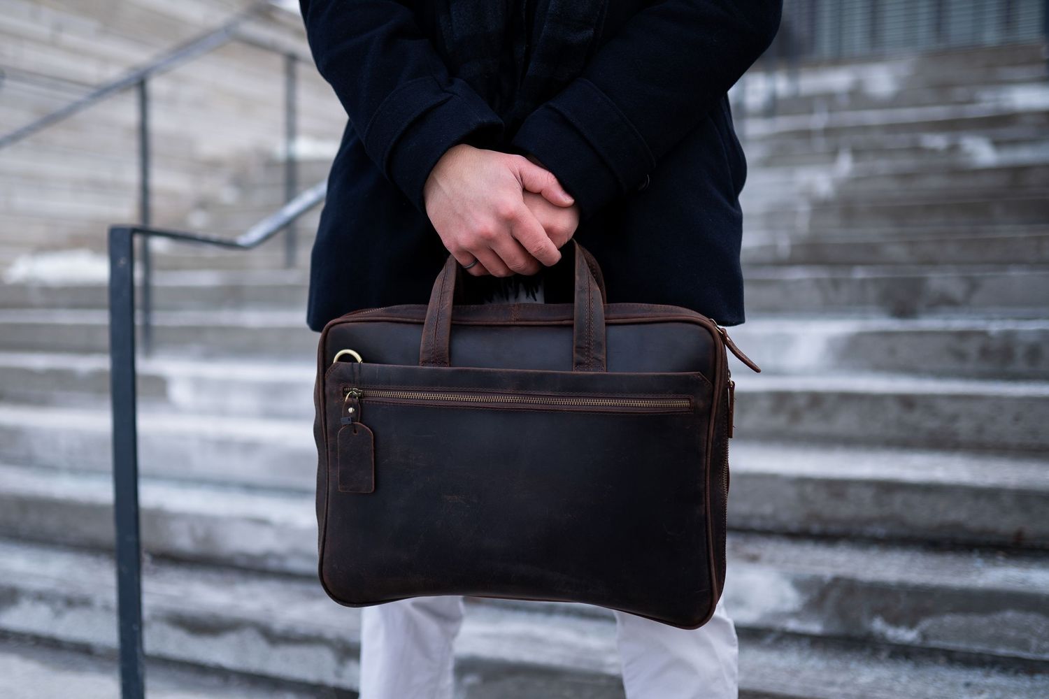 Toronto Product Photographer - Dark leather briefcase with handles being held on stone steps.