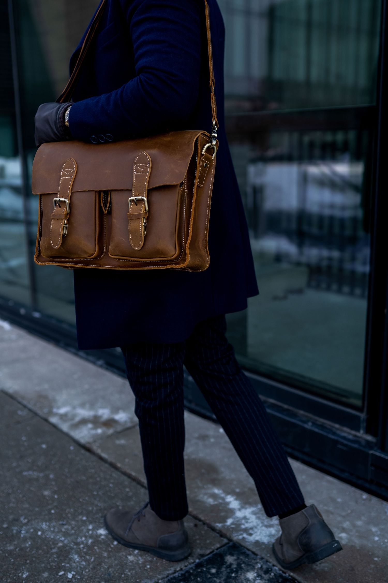 Toronto Product Photographer - Brown leather messenger bag with double front pockets worn with navy outfit.