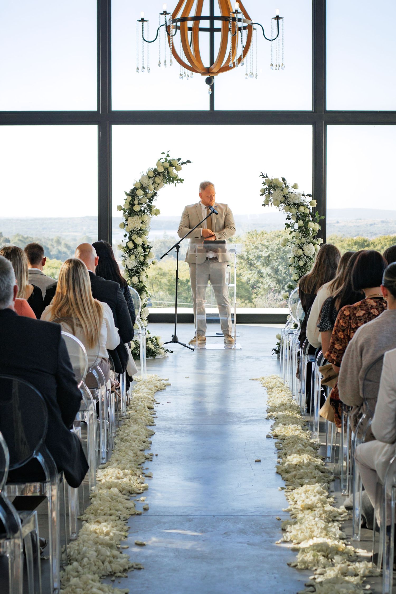 Priest waiting at the altar during a wedding ceremony, viewed down the church aisle