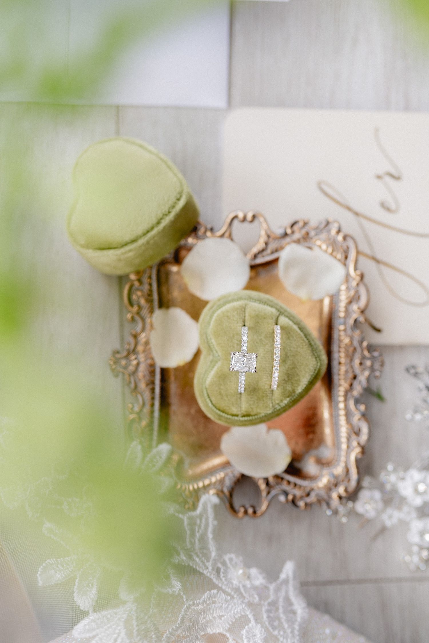 Engagement ring in mint green heart-shaped box on vintage mirrored tray.