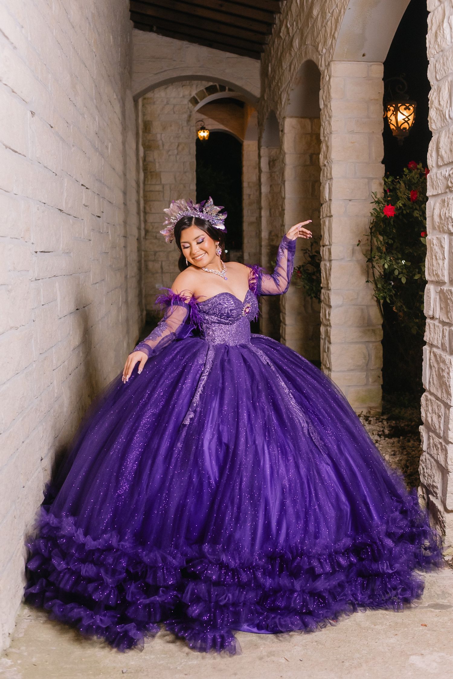 Stunning purple ball gown with ruffled tulle skirt photographed in an elegant columned hallway.