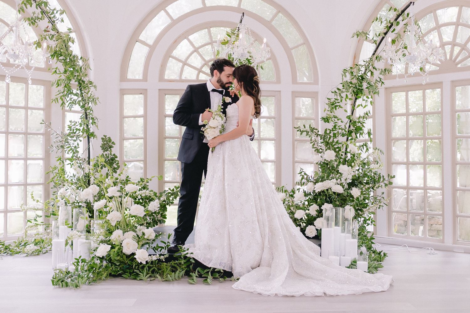 Sunlit wedding ceremony space with arched windows and romantic floral installations.