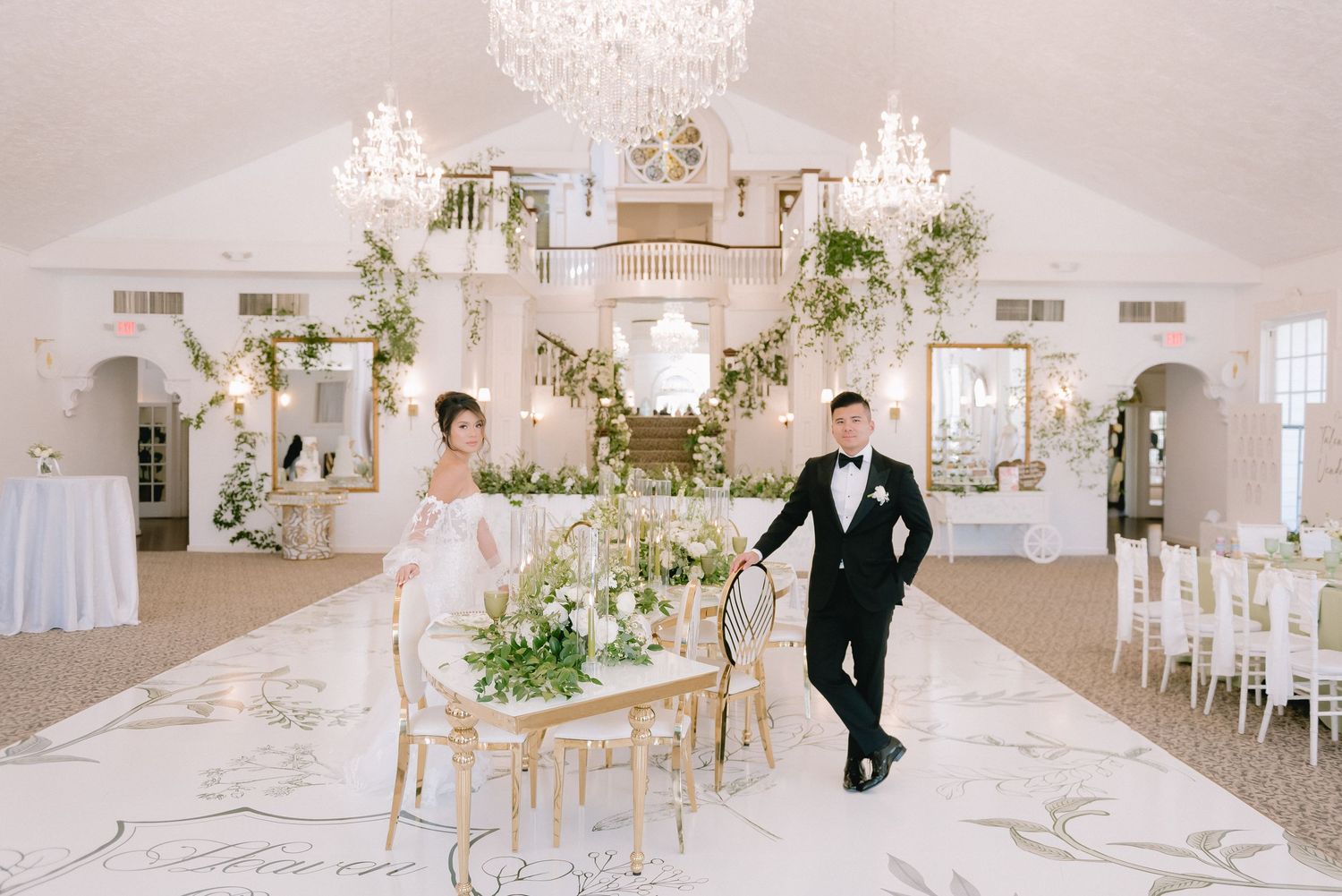 Luxurious white wedding venue with crystal chandeliers and elegant table settings.