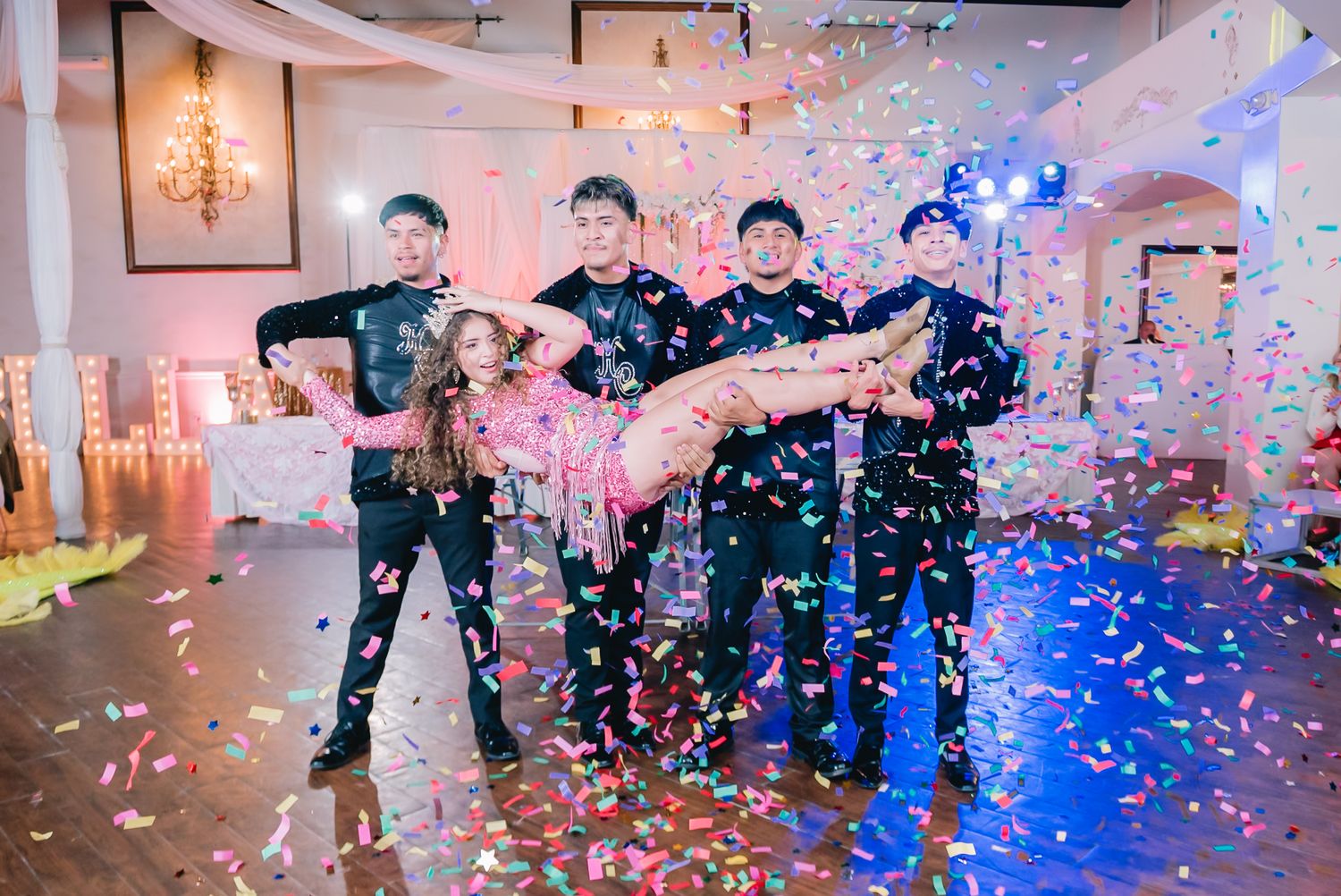 Celebratory scene with confetti and blue lighting in an elegant indoor venue.