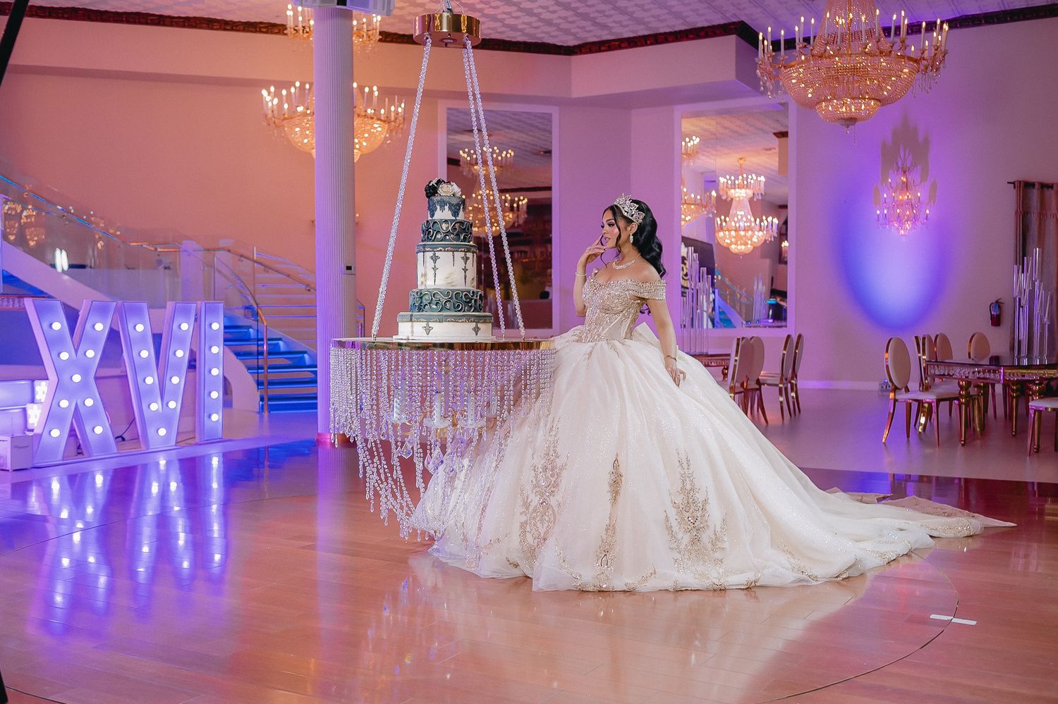 Elegant ballroom decorated in purple lighting with crystal chandeliers.