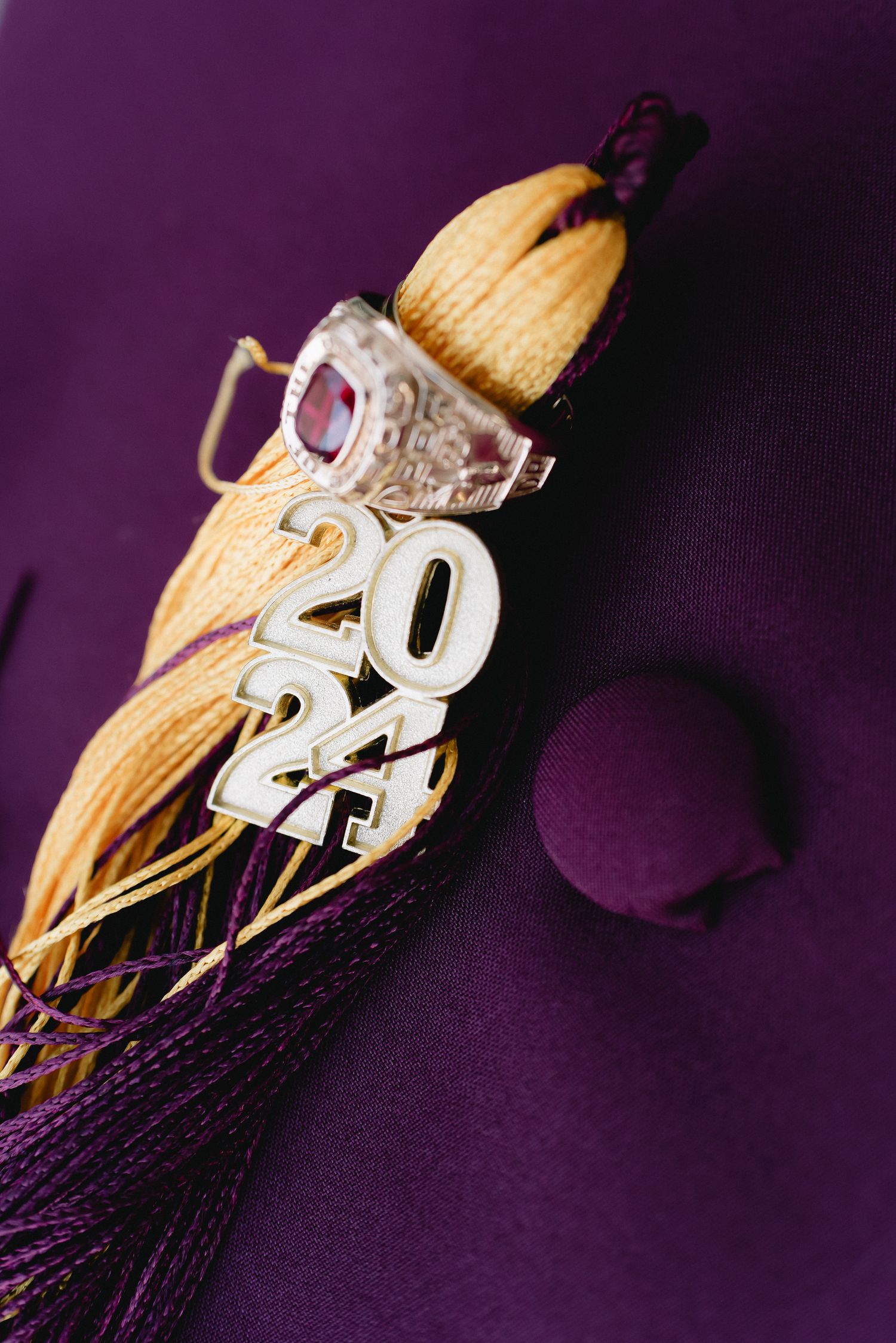 Gold graduation tassel with 2022 charm against purple background.