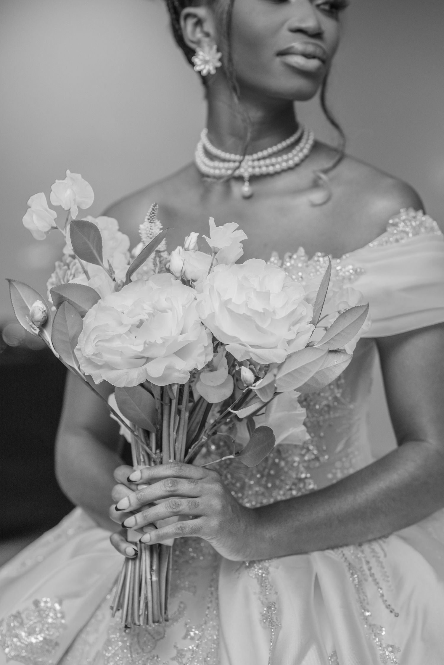 Black and white bridal portraits featuring a pearl necklace and white rose bouquet.