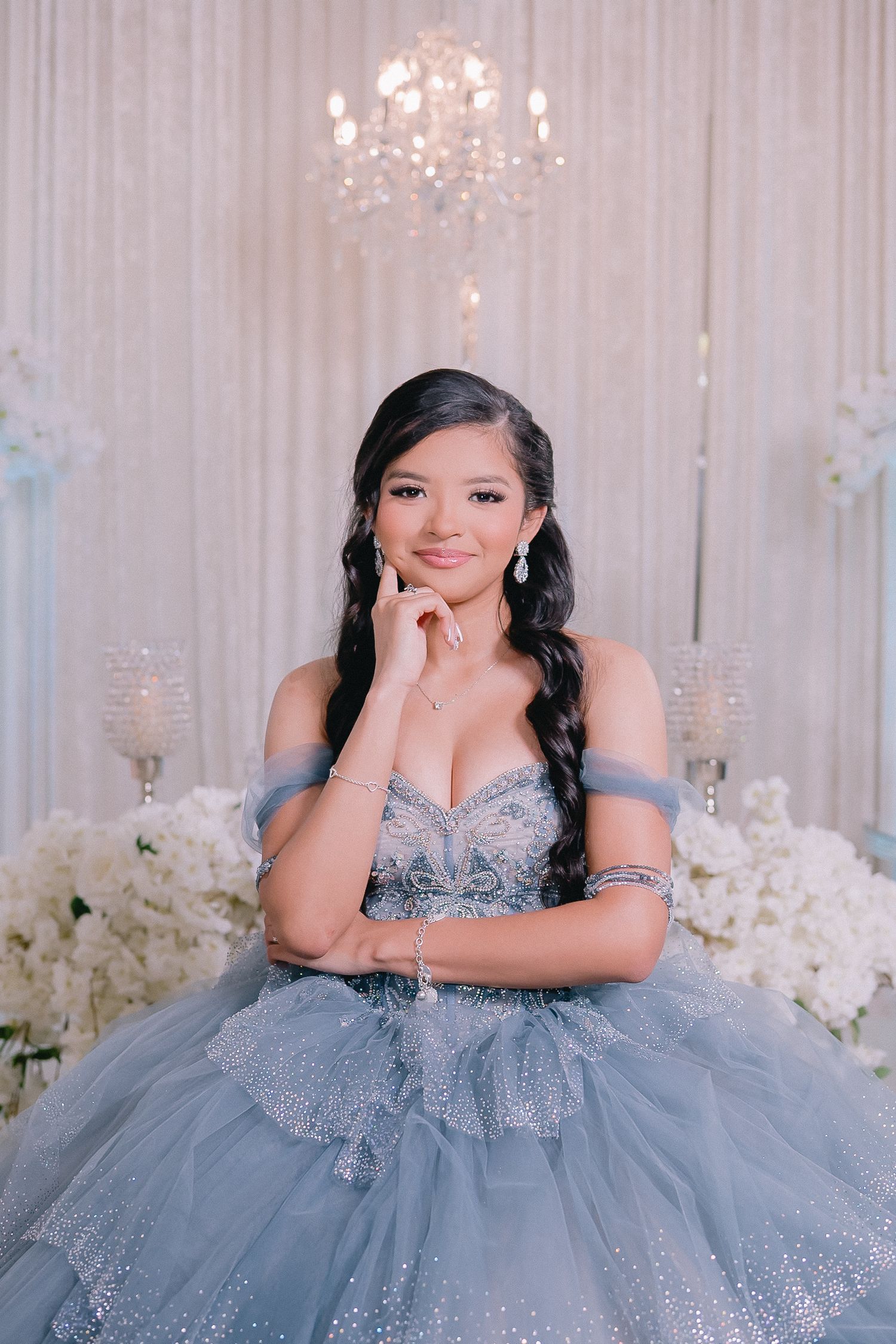 Elegant portrait session in a blue quinceañera gown with crystal chandeliers.
