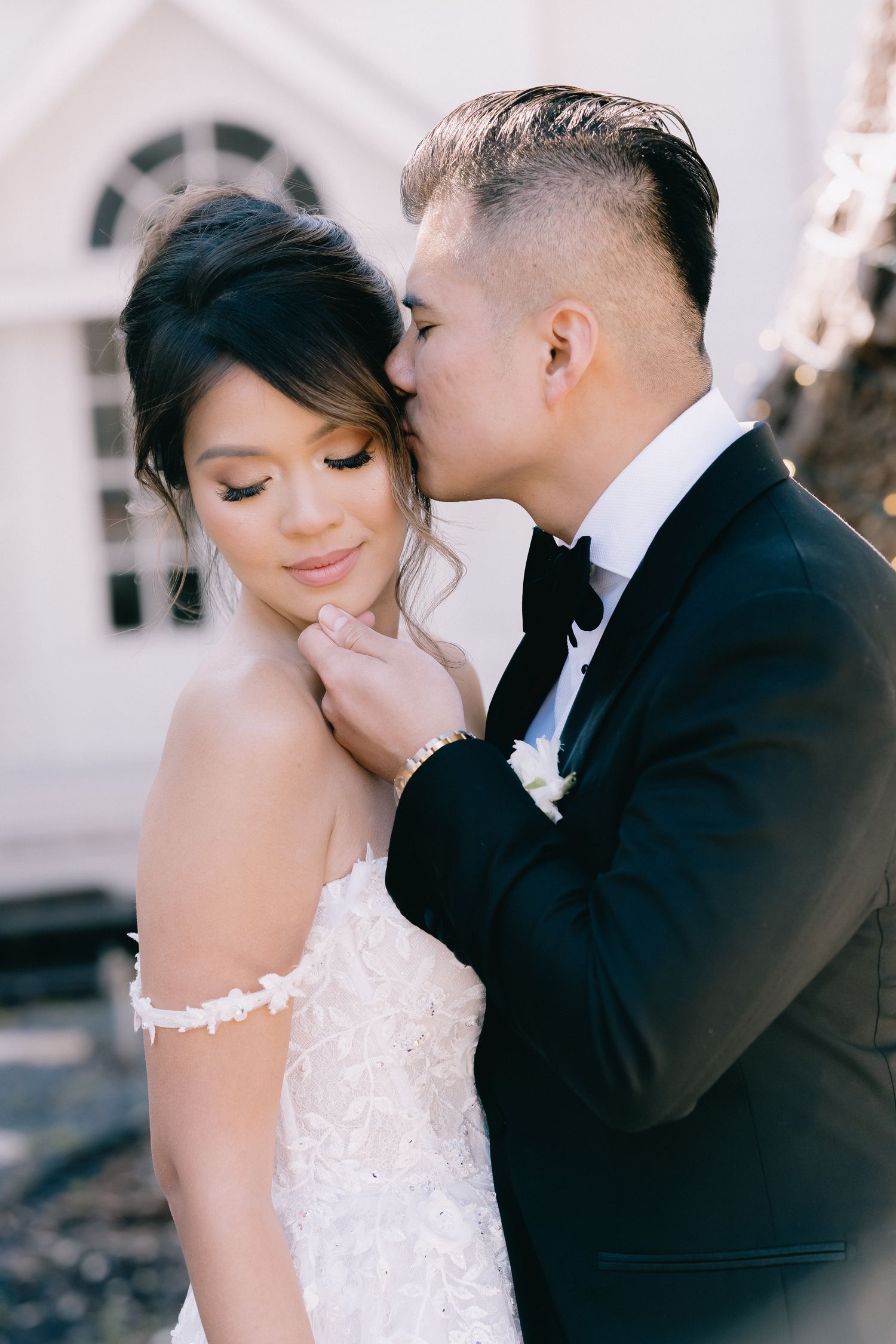 Romantic wedding couple shares intimate moments in an elegant setting with soft lighting.