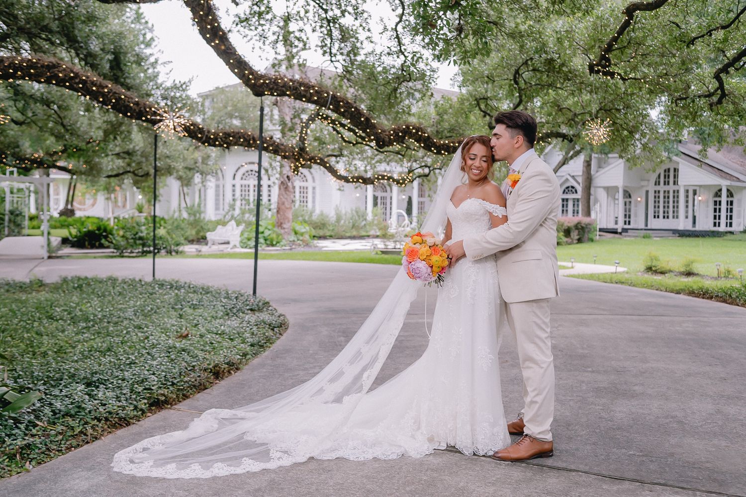 Wedding photography session under blooming trees along a peaceful garden path.
