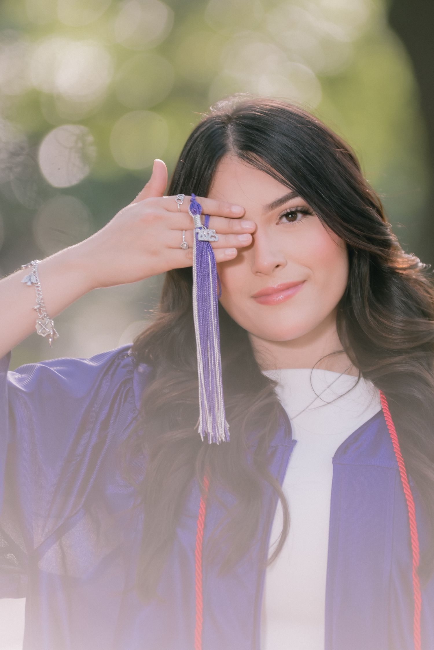 Graduation portraits showing purple cap and gown against a soft bokeh background.