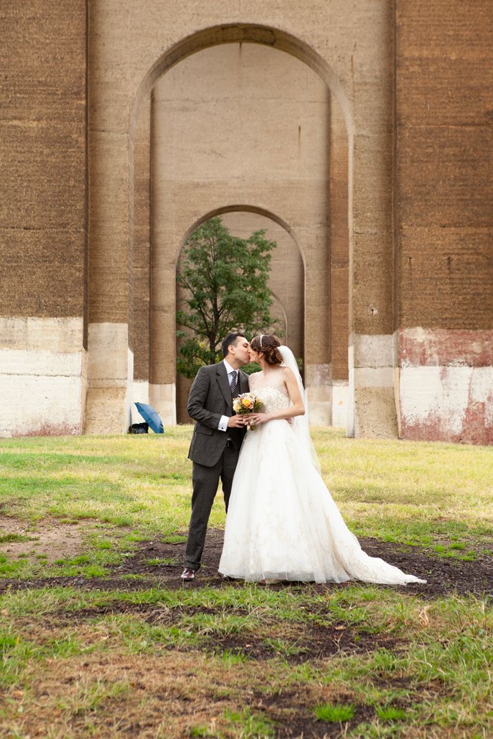 Intimate wedding moment captured under historic stone archways.