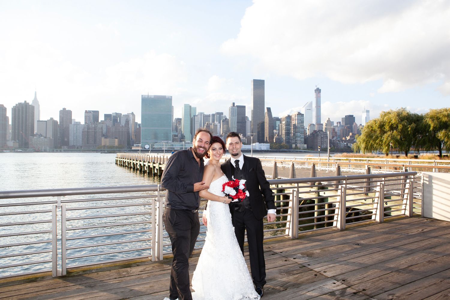 Wedding photo on wooden pier with Manhattan skyline in background.