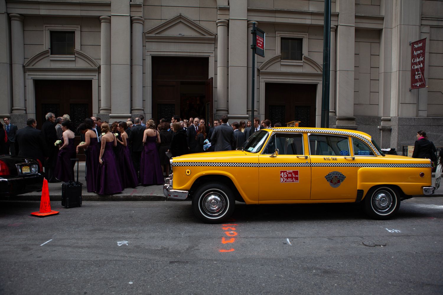 Classic yellow New York taxi cabs lined up along a city street.